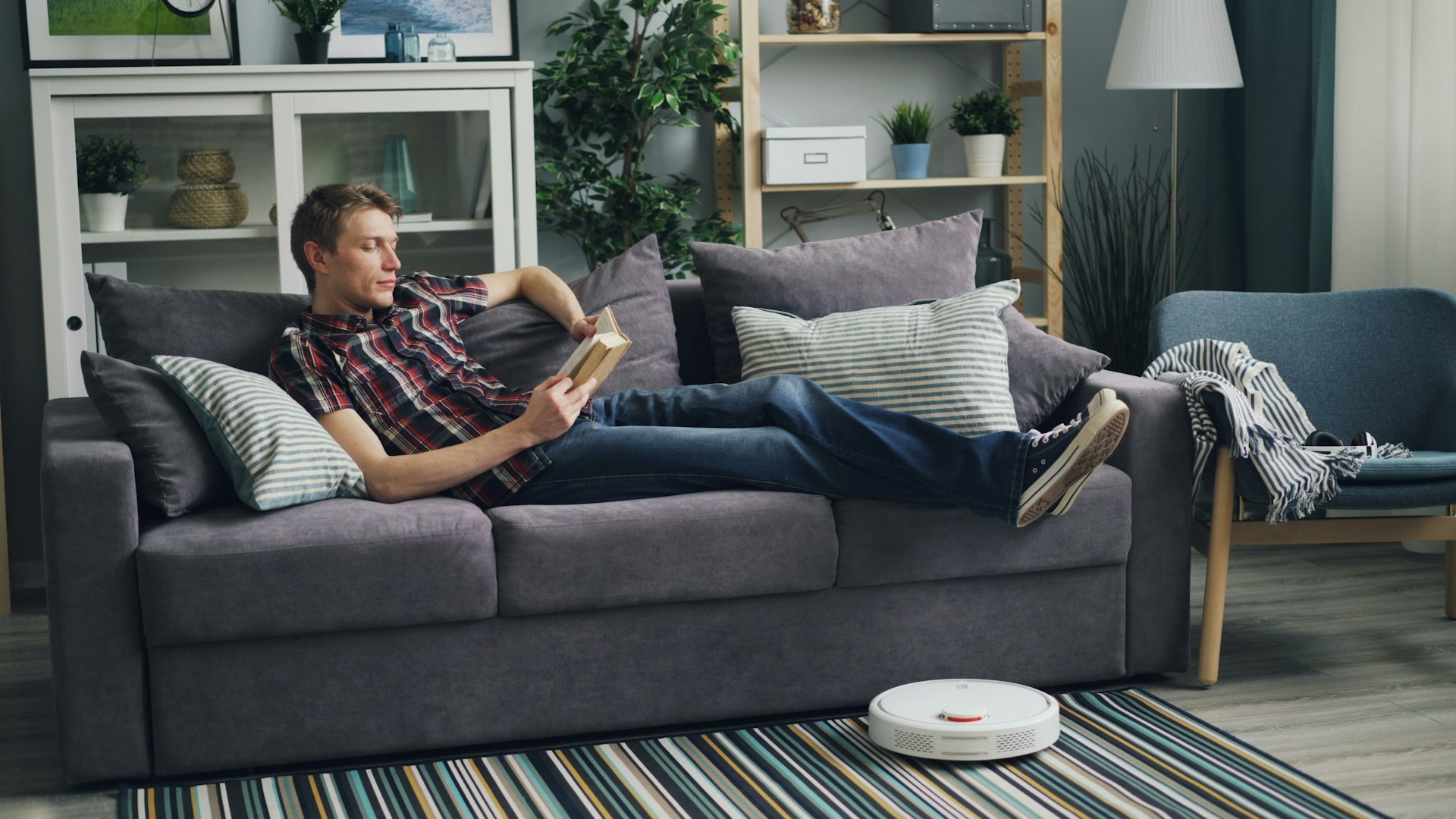 a man laying on a couch reading a book